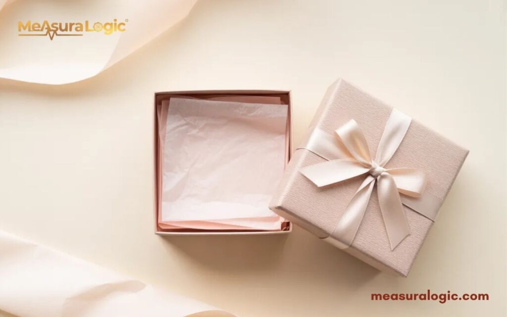 A 12 inches open light pink gift box with a matching ribbon and bow.
The inside of the box is lined with pink paper.