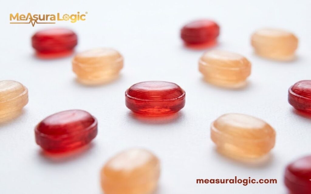 Multiple red and orange oval cough drops on white surface. Ten lozenges arranged in a sparse grid pattern.