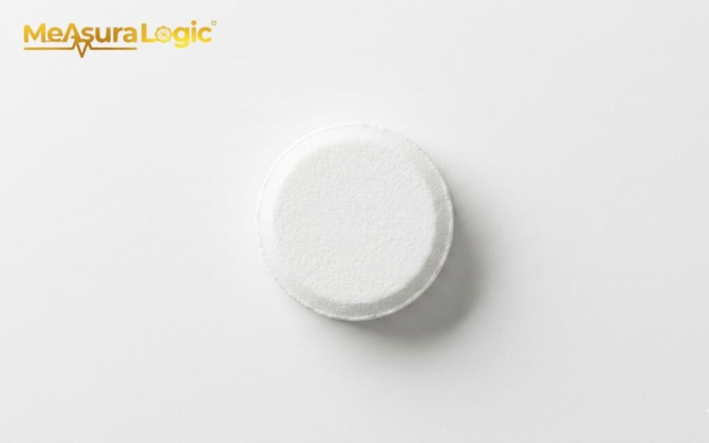 A single round generic white aspirin tablet centered on white surface. Minimalist top-down flat lay view with soft diffused lighting and a shadow.