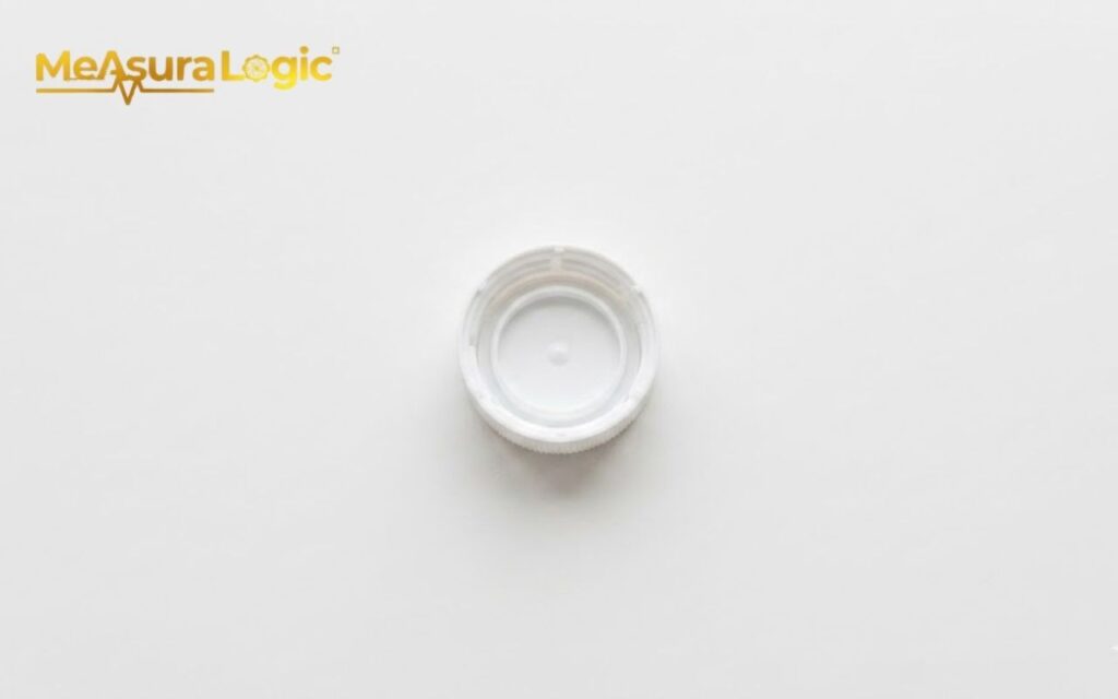 An inside view of a single white plastic bottle cap. Lying flat on a plain white background.