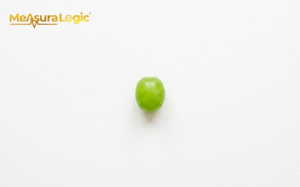 A single green 1 gram grape. Centered on a white background.
